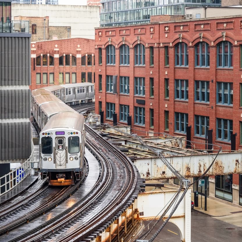 Chicago "L" train running between both modern and old buildings in downtown